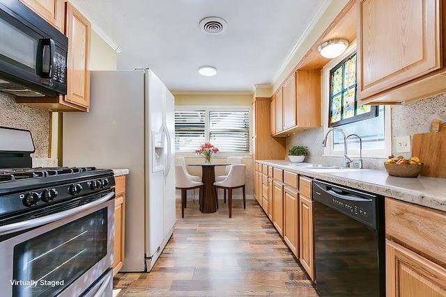 kitchen featuring sink, backsplash, black appliances, and a healthy amount of sunlight