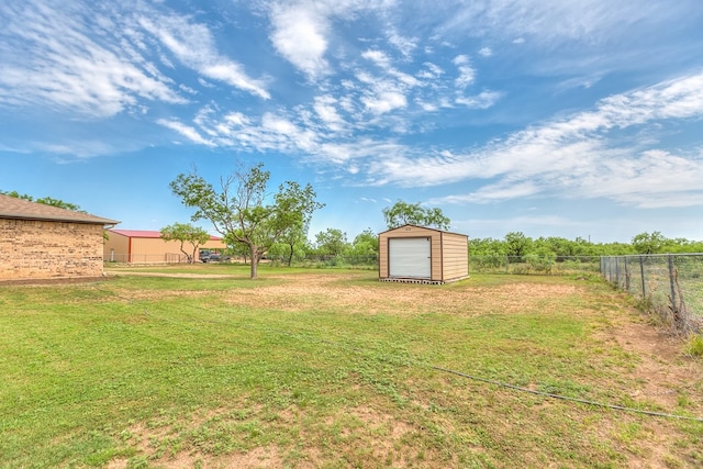 view of yard with an outdoor structure, fence, and a storage shed