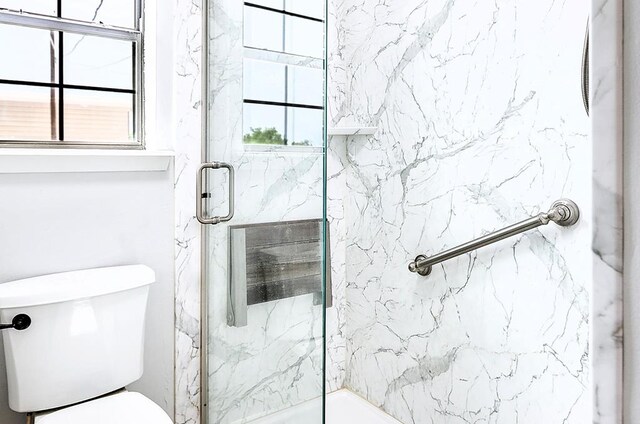 full bathroom with toilet and a marble finish shower