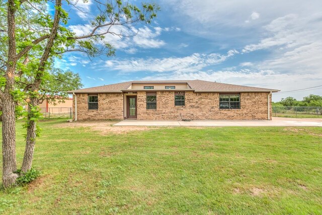 back of property featuring a lawn, fence, and a patio area