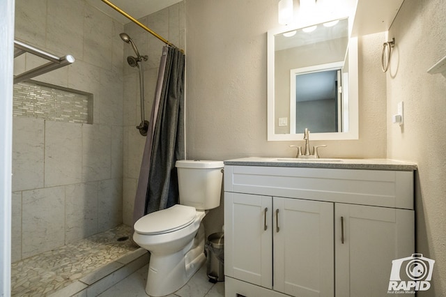 full bath with toilet, marble finish floor, tiled shower, vanity, and a textured wall