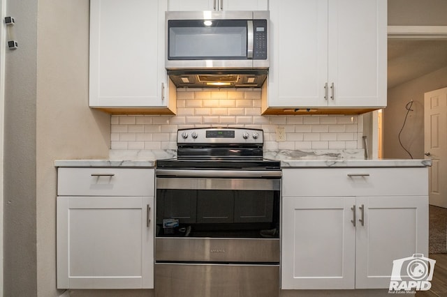 kitchen with tasteful backsplash, white cabinetry, stainless steel appliances, and ventilation hood