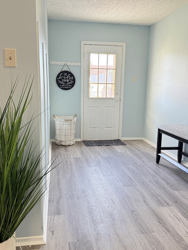 doorway featuring a textured ceiling and light hardwood / wood-style flooring