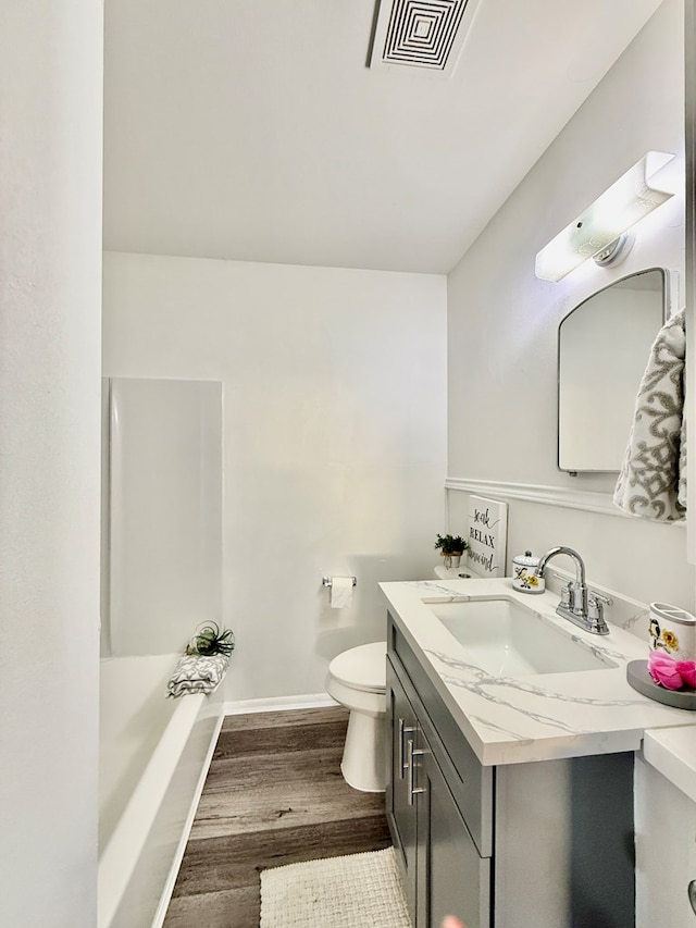 bathroom with vanity, hardwood / wood-style flooring, and toilet