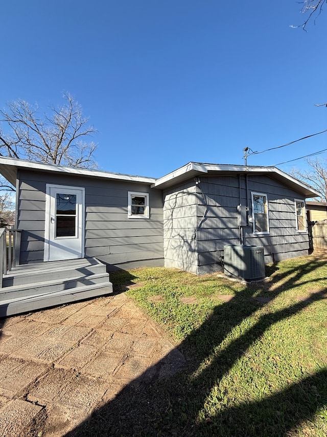 back of house with a yard and central AC unit