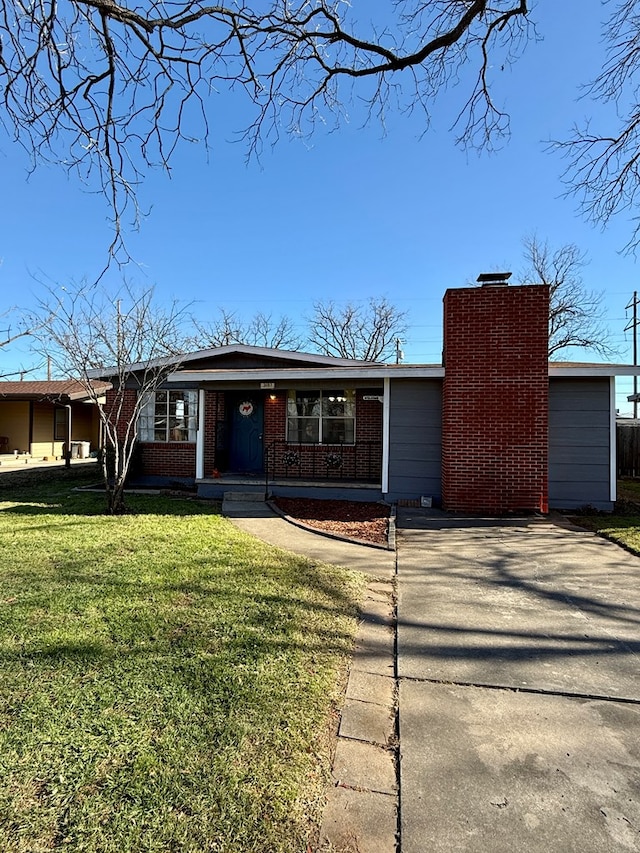 ranch-style home with covered porch and a front lawn