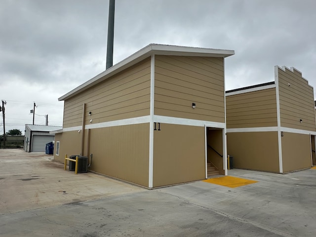 view of property exterior with an outbuilding, a garage, and central air condition unit