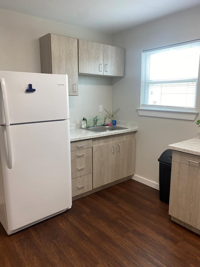 kitchen featuring white fridge, sink, light brown cabinets, and dark hardwood / wood-style flooring