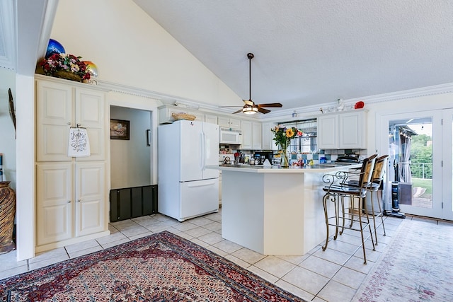 3626 Willowbrook Dr, San Angelo, TX 76904 - kitchen with light tile patterned floors, a breakfast bar area, a ceiling fan, white cabinets, and white appliances