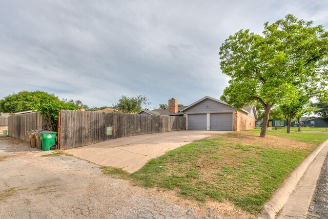 3626 Willowbrook Dr, San Angelo, TX 76904 - view of property exterior with a yard, driveway, brick siding, fence, and a garage