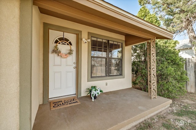 doorway to property with stucco siding and a porch