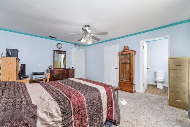 bedroom featuring light carpet, ceiling fan, and ensuite bathroom