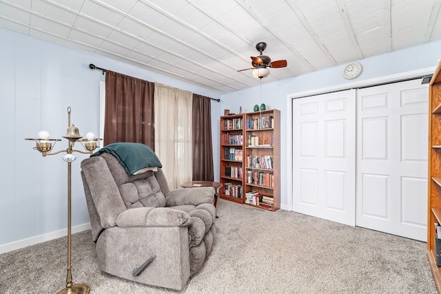 sitting room featuring carpet and ceiling fan with notable chandelier