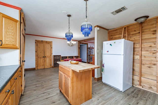 kitchen featuring a center island, white fridge, wood counters, decorative light fixtures, and light wood-type flooring