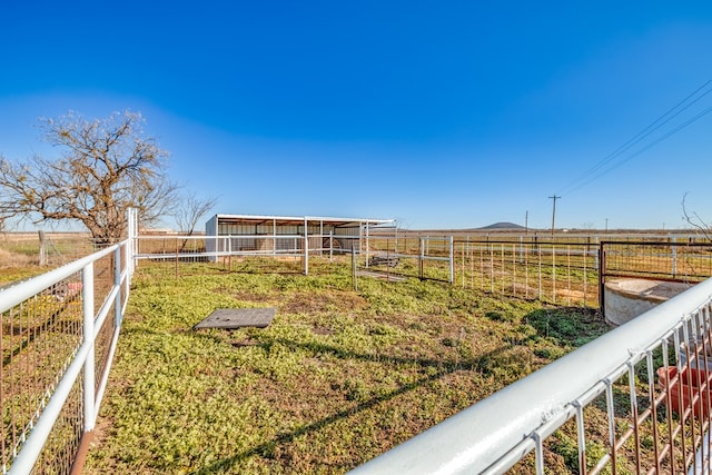 view of yard with an outbuilding and a rural view