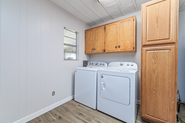 washroom with independent washer and dryer, cabinets, and light wood-type flooring