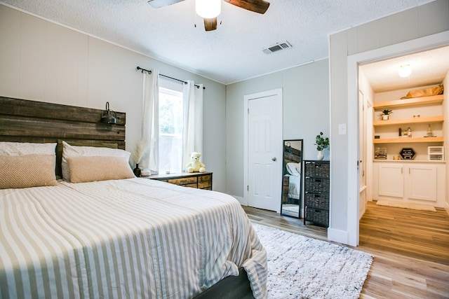 213 Paint Rock Rd, San Angelo, TX 76903 - bedroom with light wood-style flooring, a textured ceiling, and a ceiling fan