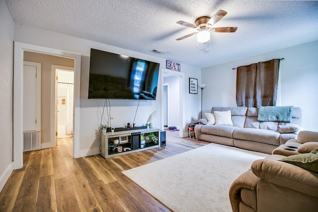 213 Paint Rock Rd, San Angelo, TX 76903 - living area with wood finished floors, a ceiling fan, baseboards, and a textured ceiling