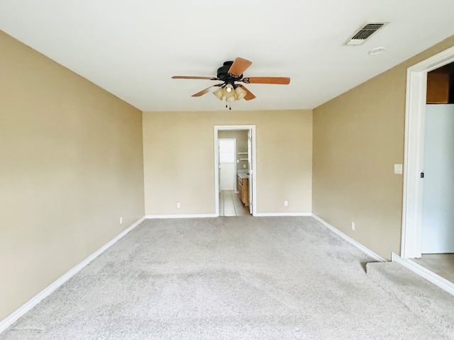 empty room featuring light colored carpet and ceiling fan