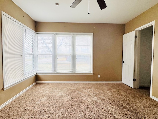 carpeted spare room with plenty of natural light and ceiling fan