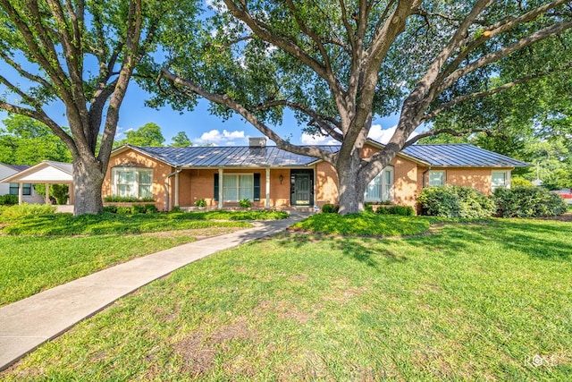 1322 S Monroe St, San Angelo, TX 76901 - ranch-style home with metal roof, brick siding, a front lawn, and a standing seam roof