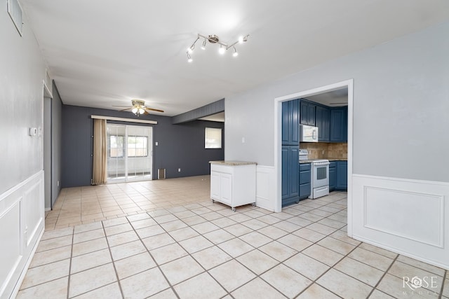 3109 College Hills Cir, San Angelo, TX 76904 - spare room featuring a decorative wall, light tile patterned floors, a ceiling fan, and wainscoting