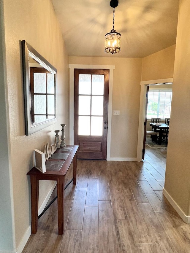 4037 Blair Ln, San Angelo, TX 76904 - doorway to outside featuring baseboards, a chandelier, plenty of natural light, and wood finished floors