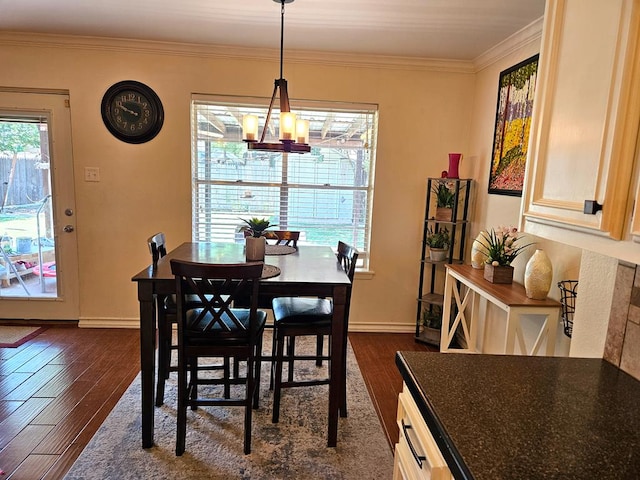 dining room with dark hardwood / wood-style flooring, a notable chandelier, and ornamental molding