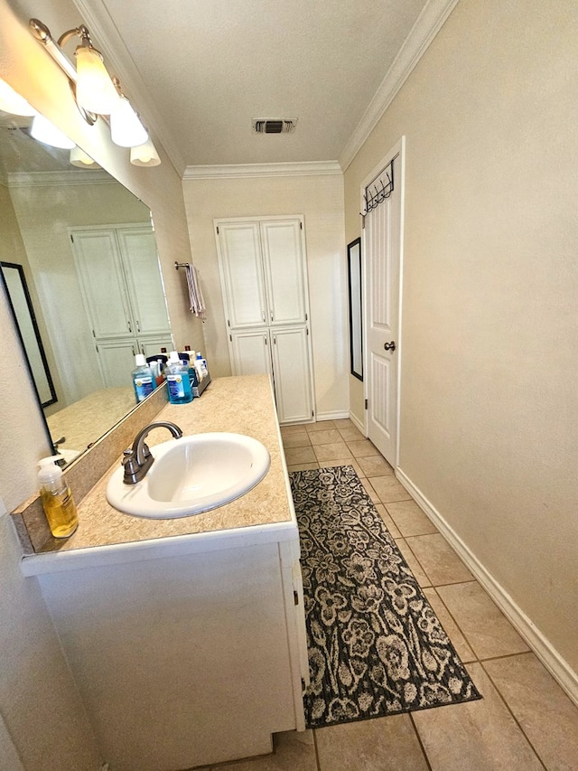 bathroom featuring crown molding, tile patterned floors, and vanity