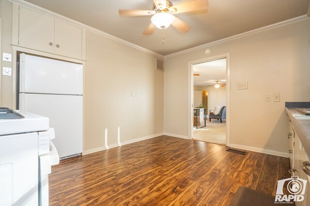 kitchen featuring white cabinetry, dark wood-type flooring, ornamental molding, and white refrigerator