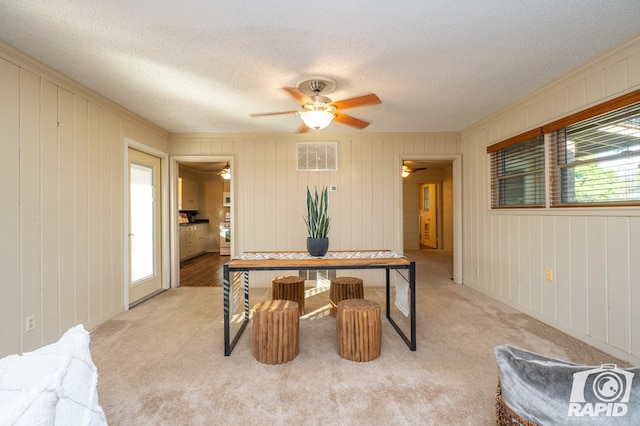 office with ceiling fan, a textured ceiling, light colored carpet, and a healthy amount of sunlight