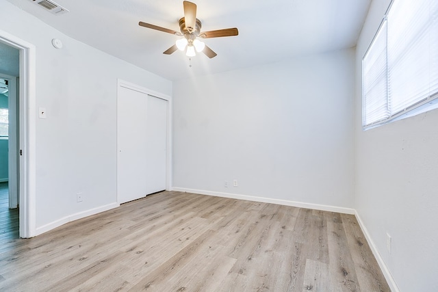 2021 Field Ave, San Angelo, TX 76901 - unfurnished bedroom featuring multiple windows, light wood-style flooring, a closet, and baseboards