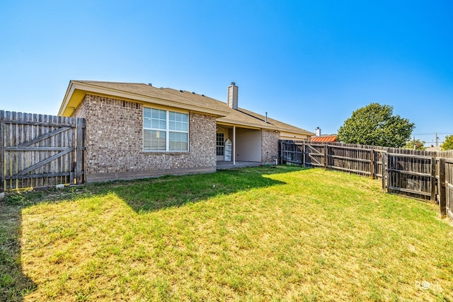 rear view of property featuring a yard