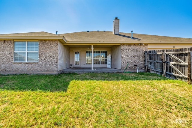 back of house featuring a patio area and a lawn