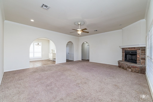 unfurnished living room with ceiling fan, ornamental molding, light carpet, and a fireplace