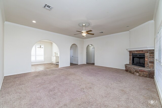 unfurnished living room featuring crown molding, a stone fireplace, light colored carpet, and ceiling fan