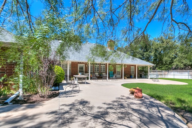 rear view of house featuring a yard and a patio area