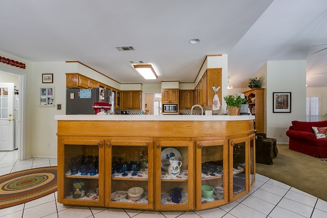 kitchen featuring light colored carpet, kitchen peninsula, and appliances with stainless steel finishes