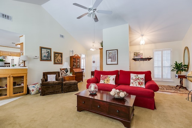 carpeted living room with high vaulted ceiling and ceiling fan