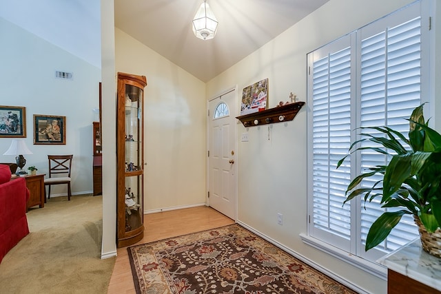 entrance foyer with vaulted ceiling and light wood-type flooring