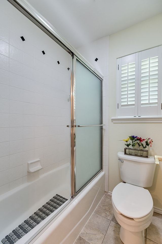 bathroom with shower / bath combination with glass door and toilet