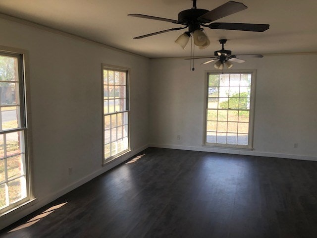 unfurnished room featuring baseboards, ornamental molding, dark wood-type flooring, and a ceiling fan