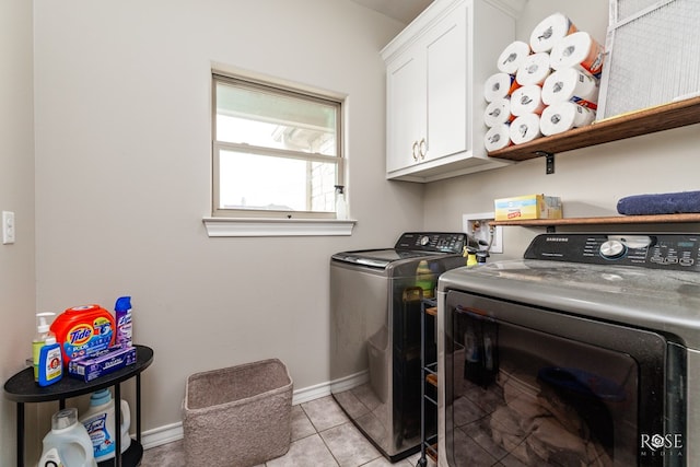 washroom featuring cabinets, light tile patterned floors, and washing machine and clothes dryer