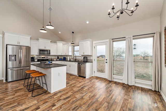 kitchen featuring sink, a center island, hanging light fixtures, appliances with stainless steel finishes, and white cabinets