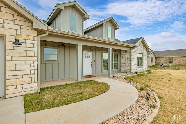 property entrance with a porch and a lawn