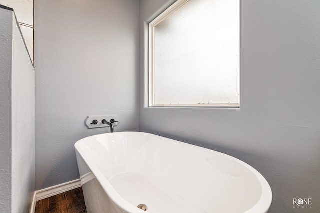 bathroom featuring wood-type flooring and a tub