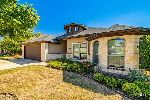 prairie-style home featuring a garage and a front yard