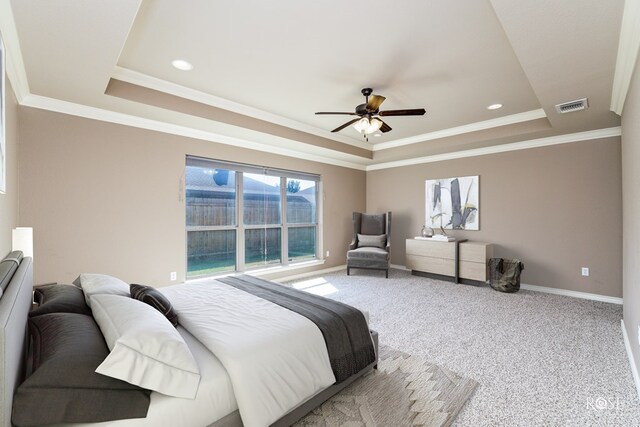 bedroom with ceiling fan, ornamental molding, a raised ceiling, and carpet