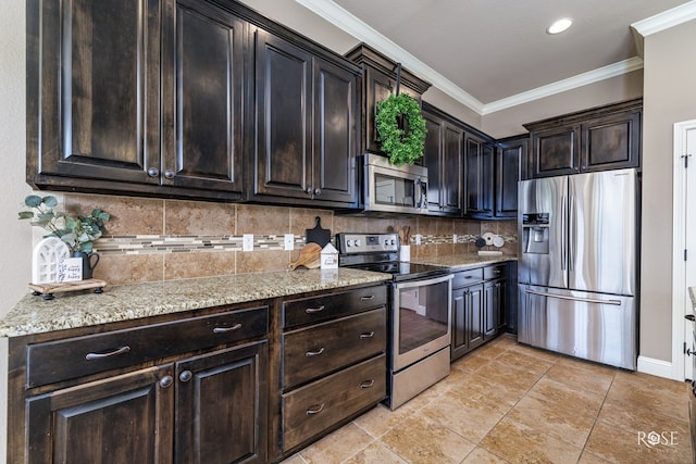 kitchen featuring crown molding, appliances with stainless steel finishes, backsplash, dark brown cabinets, and light stone countertops