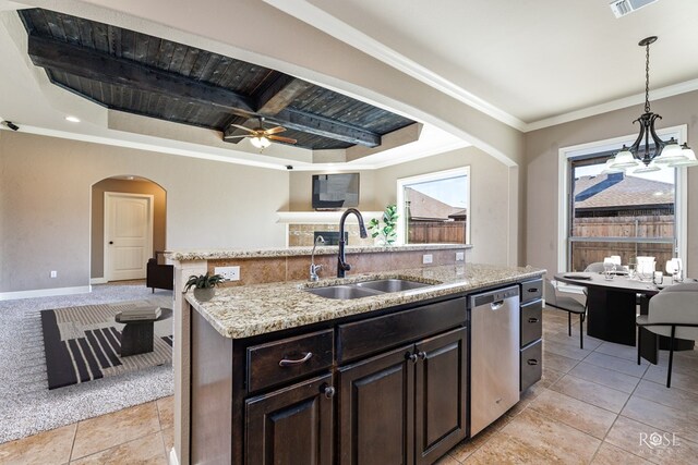 kitchen with an island with sink, sink, stainless steel dishwasher, dark brown cabinetry, and crown molding